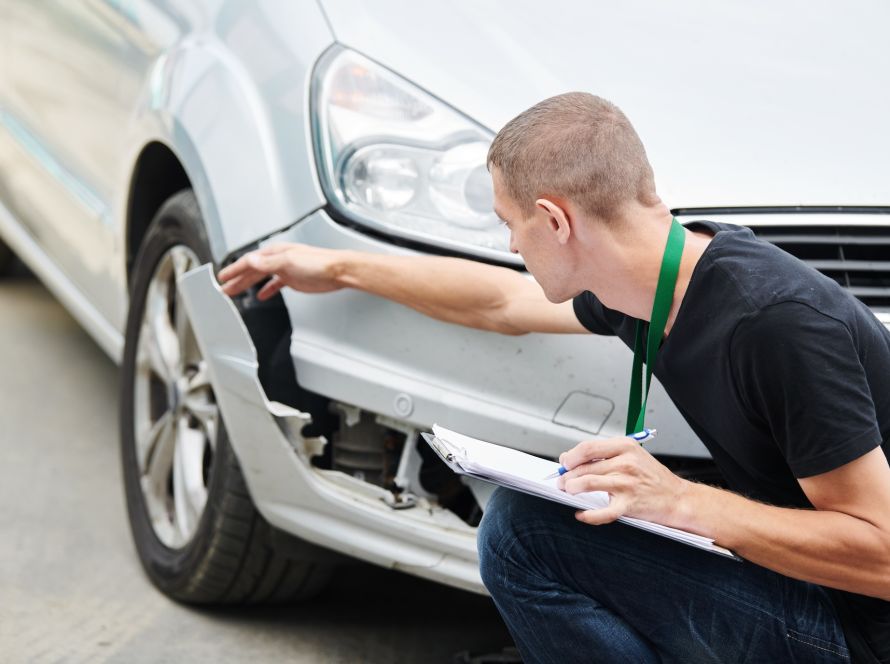 Car in collision repair shop undergoing body work